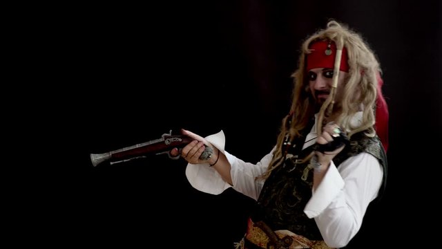 an adult man in a pirate costume holding a gun and aiming looking forward