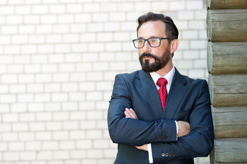 Calm man having his arms crossed and looking into the distance