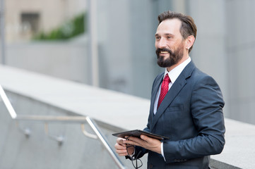 Cheerful man with modern tablet looking happy and smiling