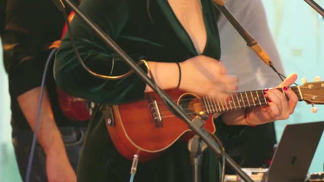 Woman playing on mandolin guitar