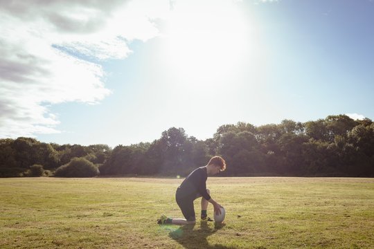 Rugby player placing rugby ball in the field - Powered by Adobe
