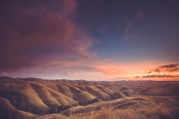 Rainy clouds, sunset sky, hills. Indonesia. Spectacular scene the bright sunset sky over the valley. Sumba. Perfect background for the different kinds of the collages and illustrations.