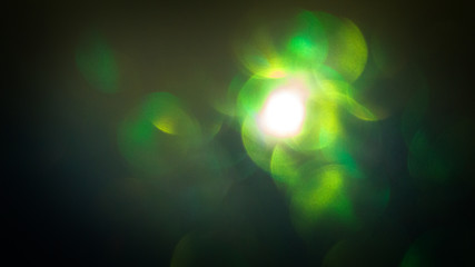 Green bokeh background, dark. Abstract Holiday Light Rays.