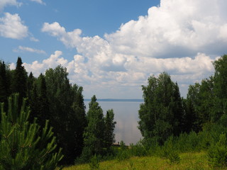 Forest by the river. Clouds in the sky. Russian summer nature. Russia, Ural, Perm region