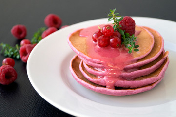 Berry vegetarian homemade pancakes on a white plate.