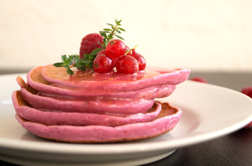 Berry vegetarian homemade pancakes on a white plate.