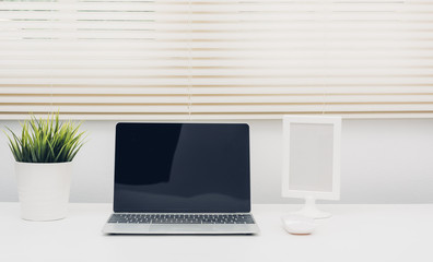 Laptop computer blank screen on white desk