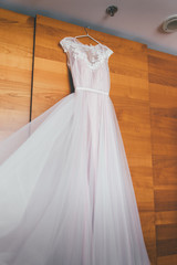 Fototapeta na wymiar Pink chiffon wedding dress hanging close up