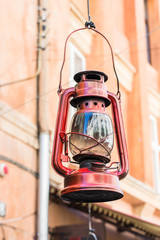 Still life of old hurricane lamp on the street. Reportage photo. Vintage lamp. Kerosene lamp. Old-fashioned equipment. Ancient decorations. Retro gas lamp.