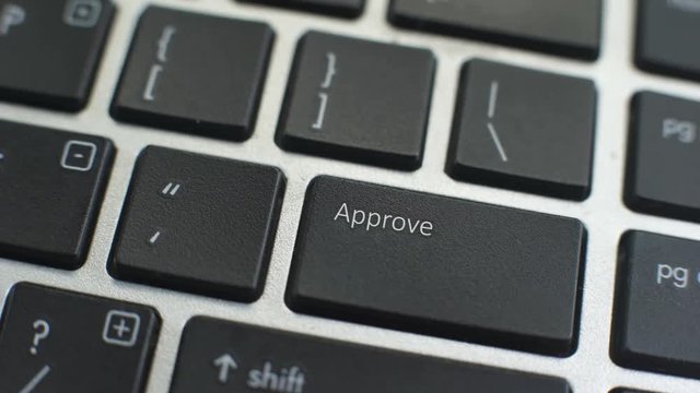 Approve button on computer keyboard, female hand fingers press key