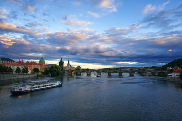 Obraz premium Famous Prague Charles bridge Vltava river with ship Czech republic tourist travel medieval architecture historical landmark