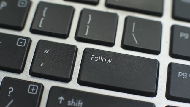 Follow button on computer keyboard, female hand fingers press key