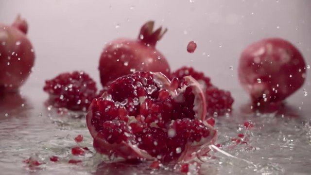 Falling splitted pomegranate into the water . Slow motion