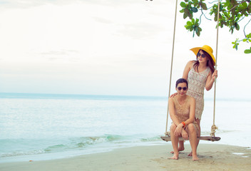 Women swing by the sea