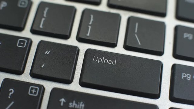 Upload button on computer keyboard, female hand fingers press key