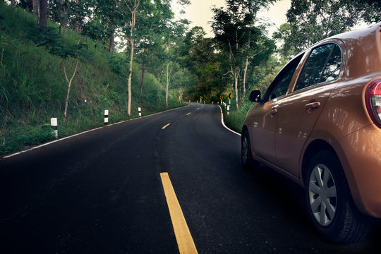 A Car Running On The Road In The Park.