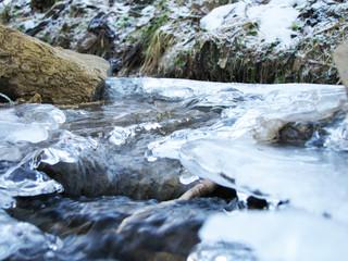 river with ice in winter forest