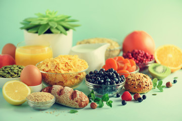 Vegetarian breakfast. Soft boiled egg, oat flakes, nuts, fruits, berries, milk, yogurt, orange, banana, peach on blue background. Healthy food diet. Copy space. Banner
