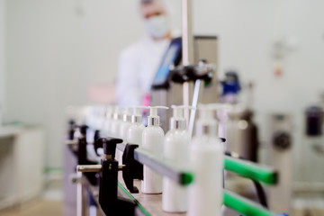 Picture of lotion bottles on production line. Bottles of cosmetic products in factory production...