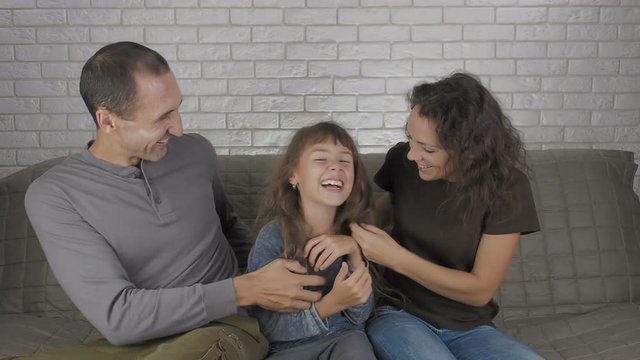 Funny family. Parents tickle the child.