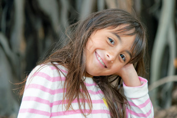 Naklejka premium Happy beautiful young girl in front of a big tree at night