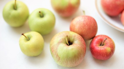 several whole apples on a white table