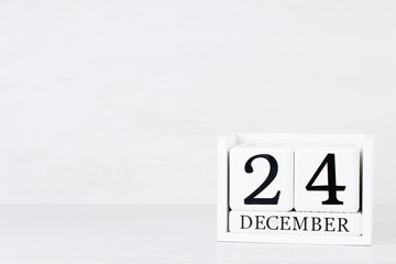 Wooden Calendar December 24 Christmas Day. On a gray background with christmas decor.