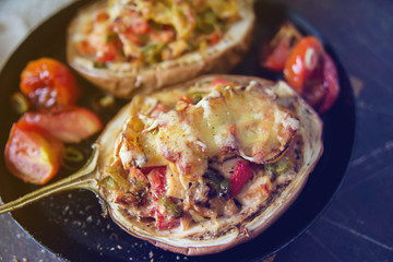 Autumn food with fresh vegetables, quick lunch: eggplant stuffed with tomatoes and cheese. The concept of healthy and vegetarian food.