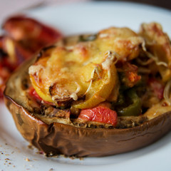 Autumn food with fresh vegetables, quick lunch: eggplant stuffed with tomatoes and cheese. The concept of healthy and vegetarian food.
