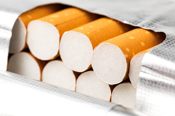 Cigarettes in a pack closeup on white background. Smoking tobacco. Bad habit