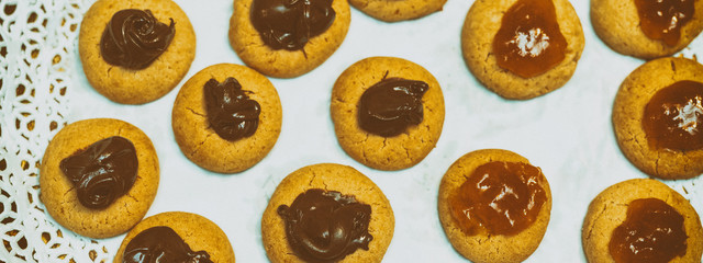 Cookies with jam and chocolate, close-up overhead view