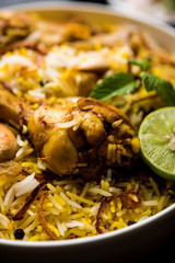 Delicious spicy chicken biryani in bowl over moody background, it’s a popular Indian and Pakistani food.