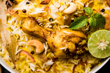 Delicious spicy chicken biryani in bowl over moody background, it’s a popular Indian and Pakistani food.