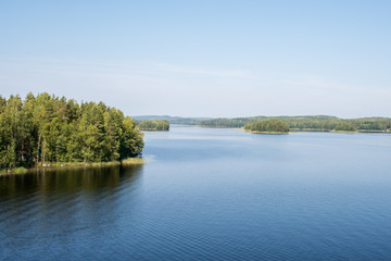 Fototapeta na wymiar weite Seenlandschaft mit blauem Wasser und grünen Inseln