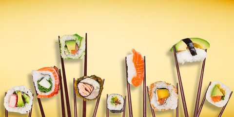 Traditional japanese sushi pieces placed between chopsticks, separated on pastel background.