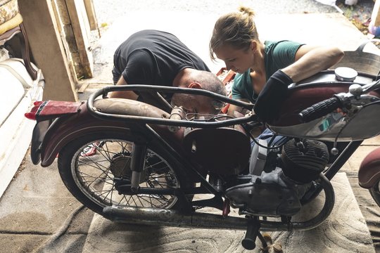 Mechanic repairing motorbike in garage