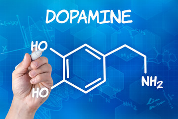 hand with pen drawing the chemical formula of Dopamine