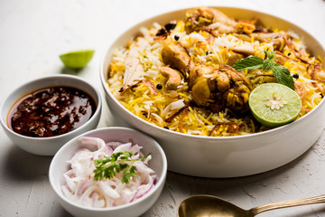 Delicious spicy chicken biryani in bowl over moody background, it’s a popular Indian and Pakistani food.