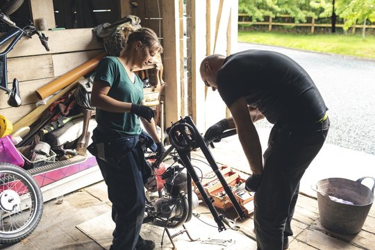 Mechanic repairing motorbike in garage