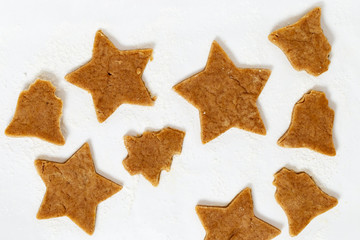 Gingerbread Cookies on paper background. New Year figures from dough, prepared for baking in oven. Biscuits in form of star and bell for baking.
