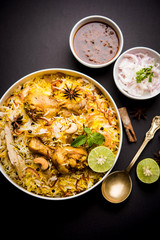 Delicious spicy chicken biryani in bowl over moody background, it’s a popular Indian and Pakistani food.