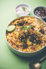 mutton or lamb biriyani with basmati rice, served in a bowl over moody background.
