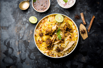 mutton or lamb biriyani with basmati rice, served in a bowl over moody background.