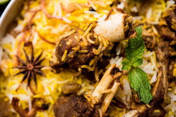 mutton or lamb biriyani with basmati rice, served in a bowl over moody background.