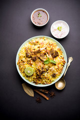 mutton or lamb biriyani with basmati rice, served in a bowl over moody background.