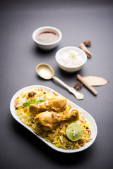 Delicious spicy chicken biryani in bowl over moody background, it’s a popular Indian and Pakistani food.