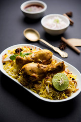 Delicious spicy chicken biryani in bowl over moody background, it’s a popular Indian and Pakistani food.