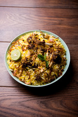 mutton or lamb biriyani with basmati rice, served in a bowl over moody background.
