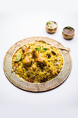 Delicious spicy chicken biryani in bowl over moody background, it’s a popular Indian and Pakistani food.