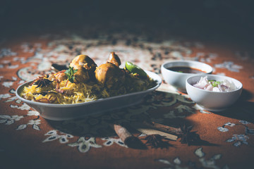 Delicious spicy chicken biryani in bowl over moody background, it’s a popular Indian and Pakistani food.
